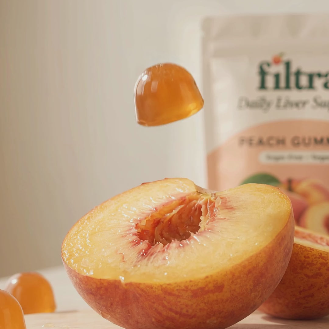 A Filtra peach gummy landing on a fresh peach half